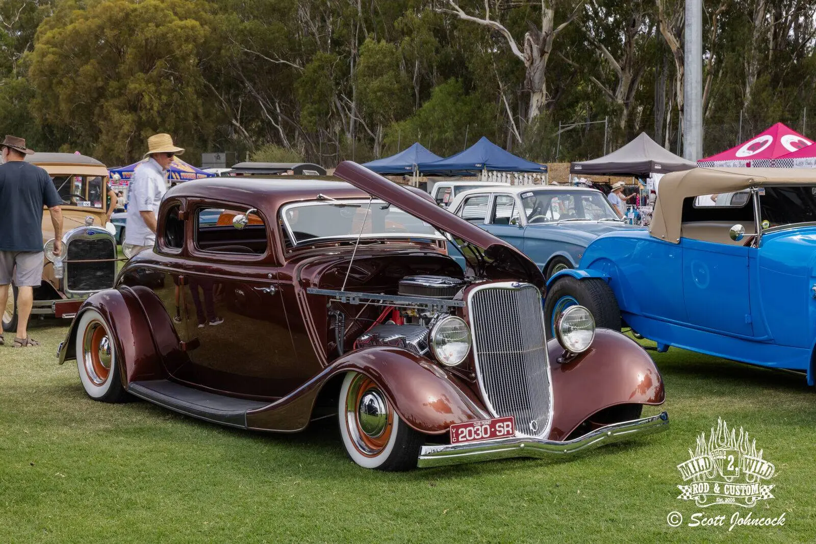 Maroon hot rod with engine displayed
